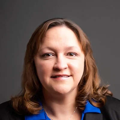Chiropractor Amanda Pennekamp Smiling In Blue Collared Shirt