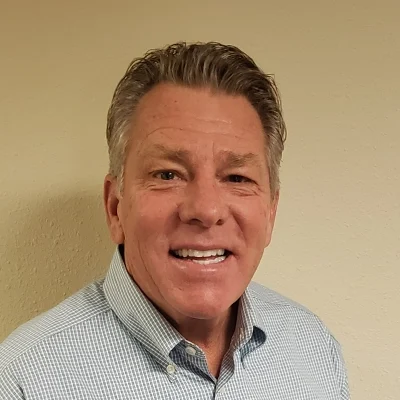 Chiropractor Fond du Lac WI Craig Wink About Chiropractor Craig Wink Smiling In Dress Shirt On Tan Background