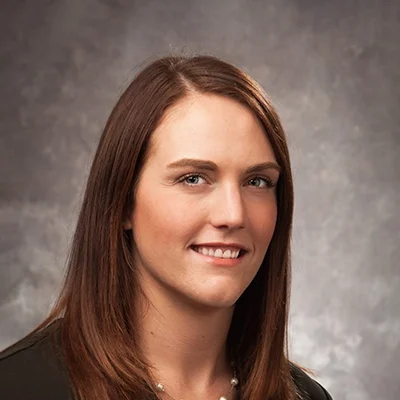 Chiropractor Jennifer Voelz Smiling In Black Top With Necklace