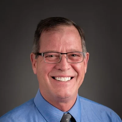 Chiropractor Mark McCann Smiling In Blue Dress Shirt