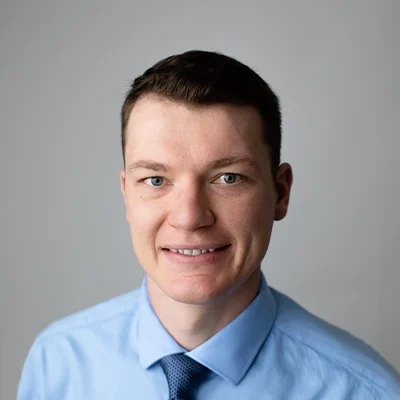 Chiropractor Sauk City WI Brandon Wedig About Chiropractor Brandon Wedig Smiling In Dress Shirt and Dark Blue Tie