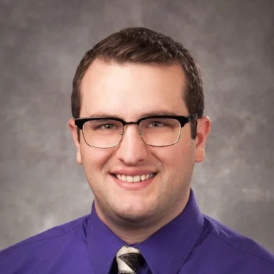 Chiropractor Nicholas Petrulis Smiling In Purple Dress Shirt