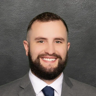 Chiropractor Nicholas Petrulis Smiling In gray suit jacket