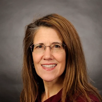 Functional Medicine Madison WI Laurie Bigelow About Massage Therapist Laurie Bigelow Smiling In Red Top