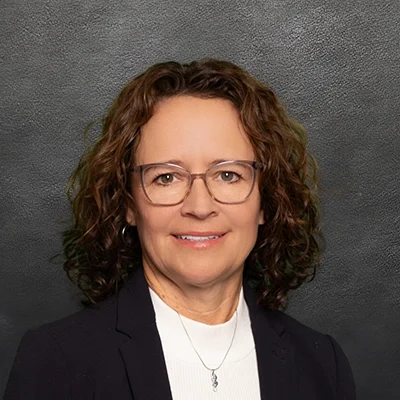 Tori Horkan Smiling In Front Of Black Wall