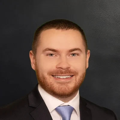 Doctor of Physical Therapy Nathan Mohr Smiling In Front Of Black Wall