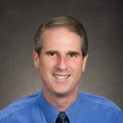 LSM Chiropractic Chiropractor Jeffrey Lyne Chiropractor Jeffrey Lyne Smiling In Blue Dress Shirt